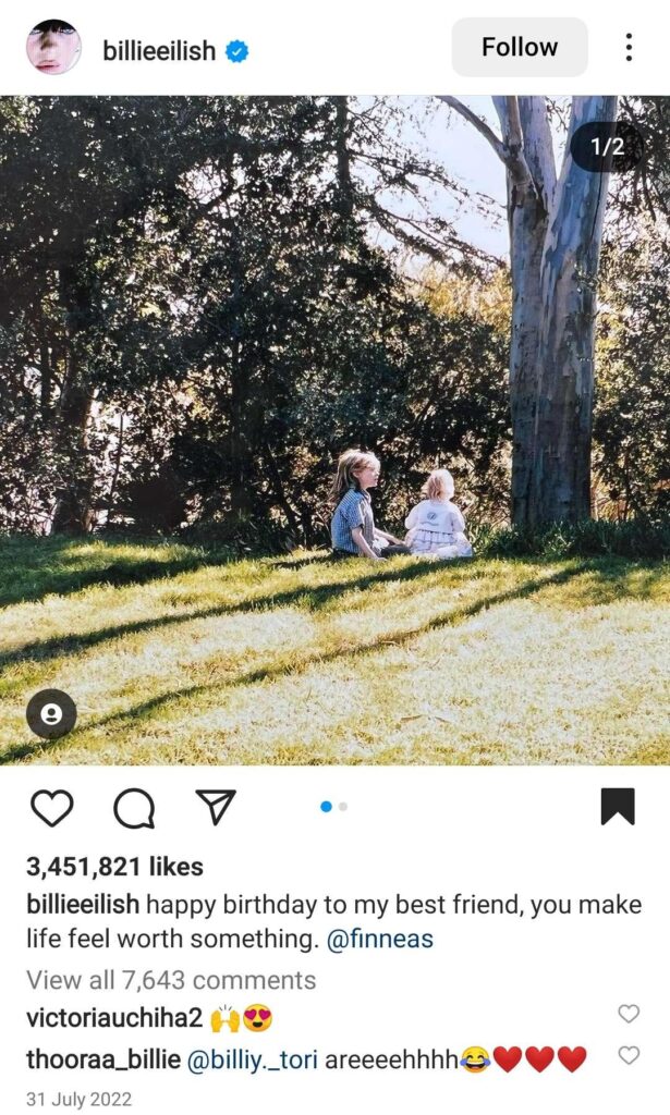 Two little kids under a tree in a big garden.