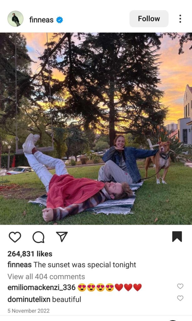 Finneas and his girlfriend with their pet dog in their home garden.