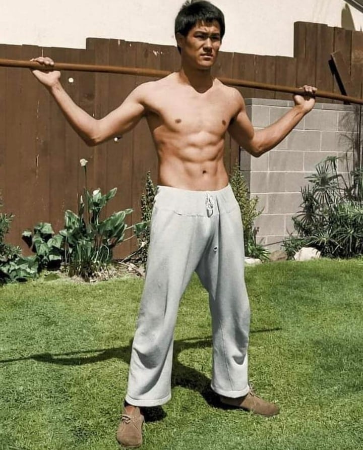 Bruce Lee standing in his backyard garden