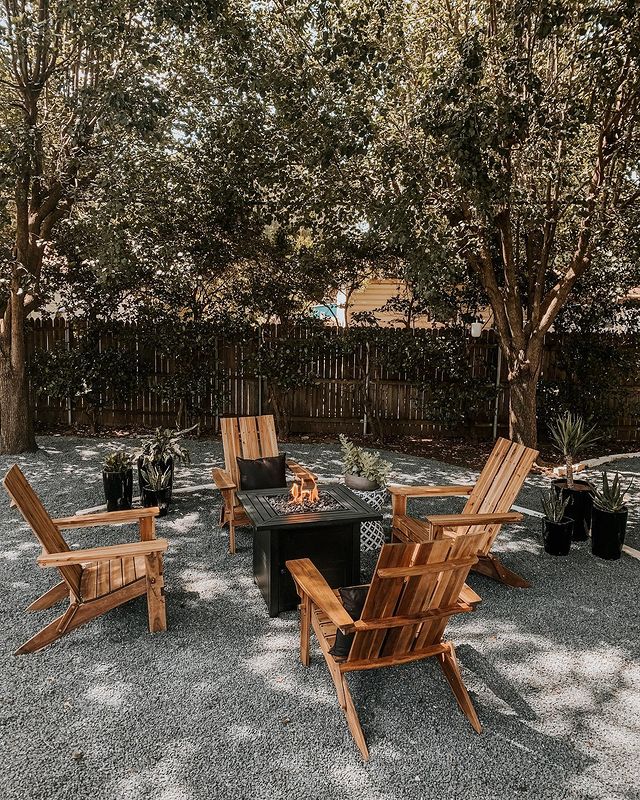 A patio with woode chai and firepit in the middle