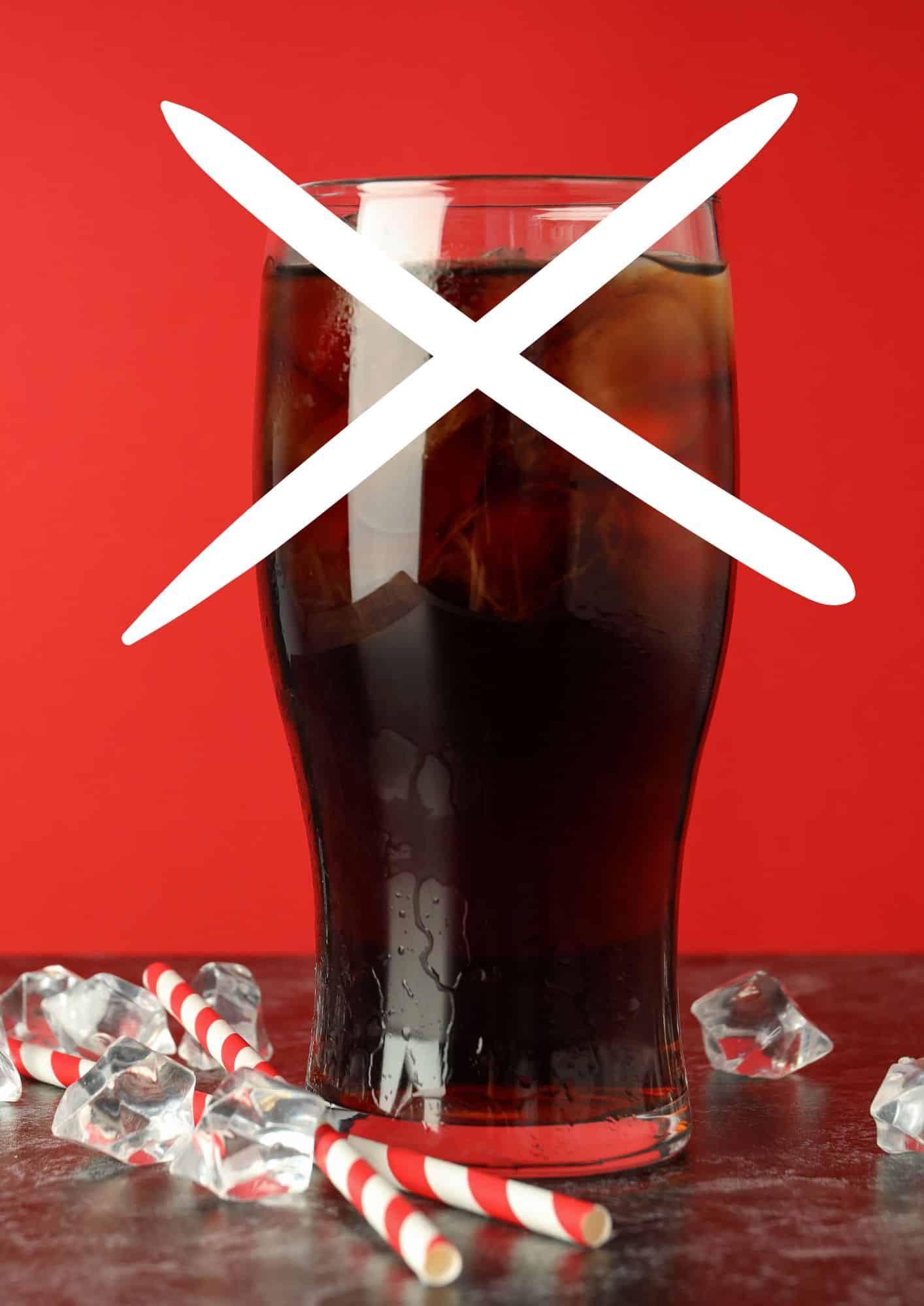 Coca cola with ice cubes and straw on a table